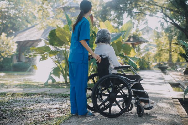 a nurse take care a senior male on wheelchair in his garden at h a nurse take care a senior male on wheelchair in his garden at h